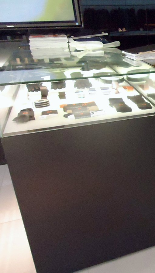 Dark counter with a lit glass display case of accessories