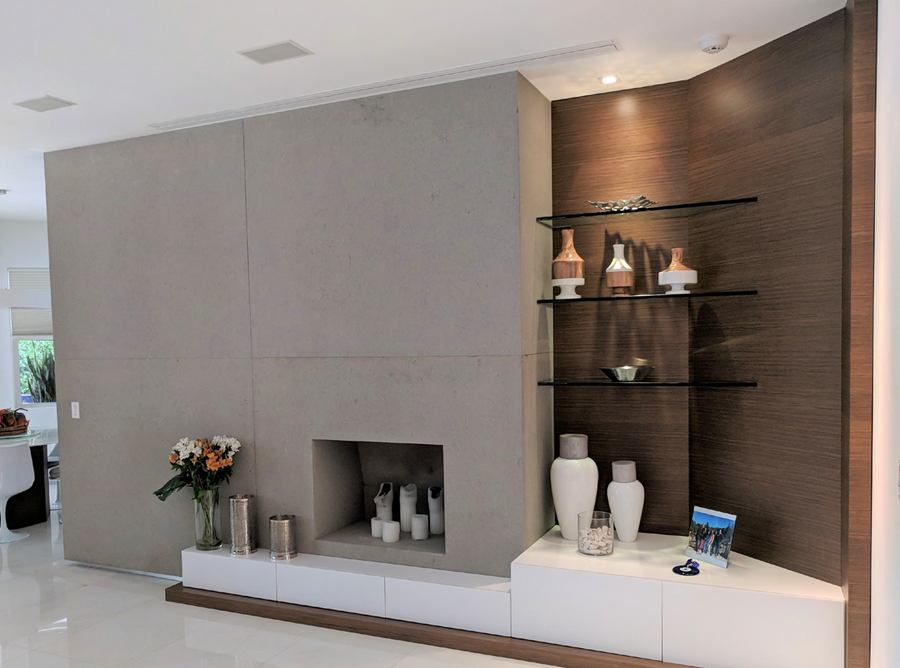 Fireplace wall with white low storage, wood panel and glass shelves